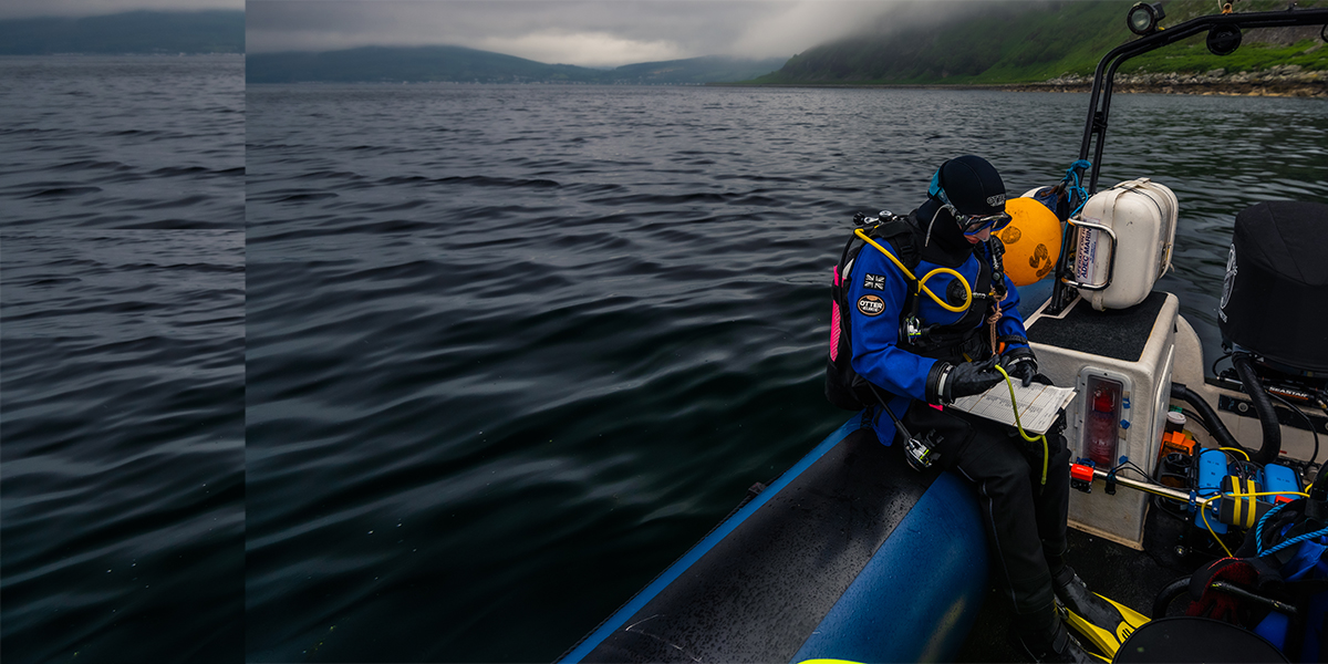 Univeristy of York Environment and Geography marine researcher sat in a wearing diving equipment on the Isle of Arran